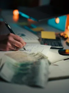 Calculator and financial paperwork used to calculate rental income tax and expenses for property investors in South Africa